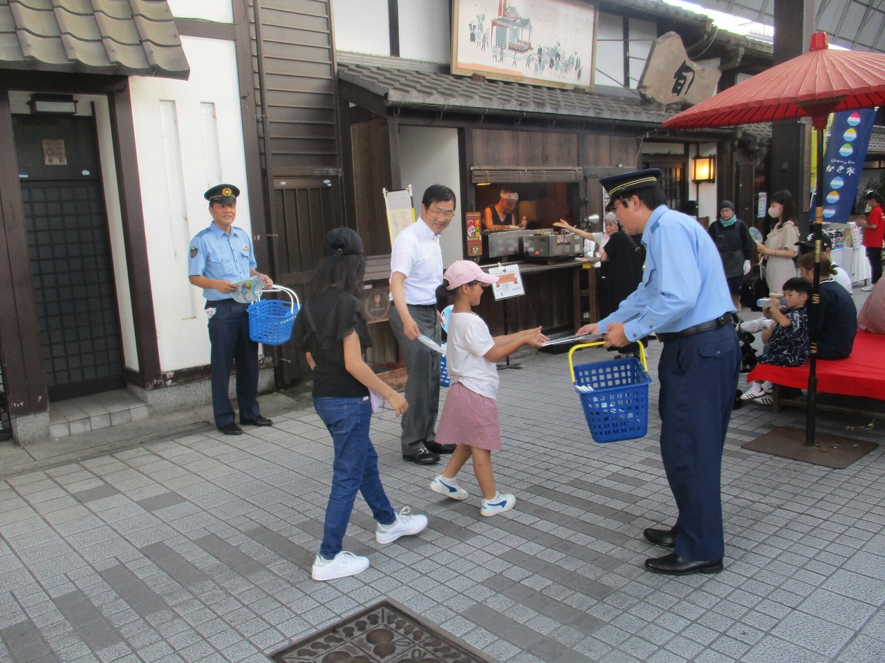 警察官が啓発品のうちわを配る様子