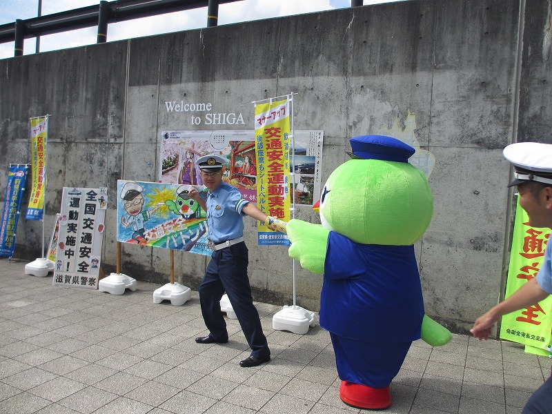 たかピーからバトンを受ける大津北警察署長