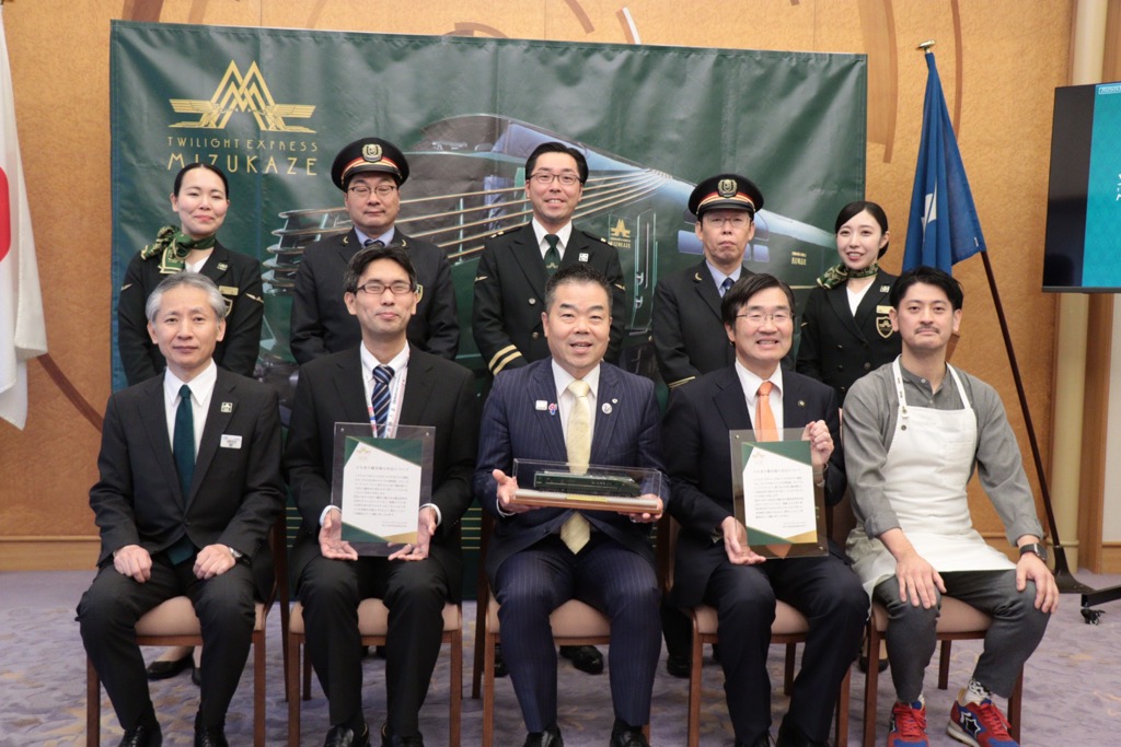 前左から、発表した財JR西日本京滋支社長、辻近江八幡市総合政策部長、三日月知事、浅見長浜市長、市山シェフ。後列は近江八幡駅長、木ノ本駅長、瑞風クルーの皆さん。