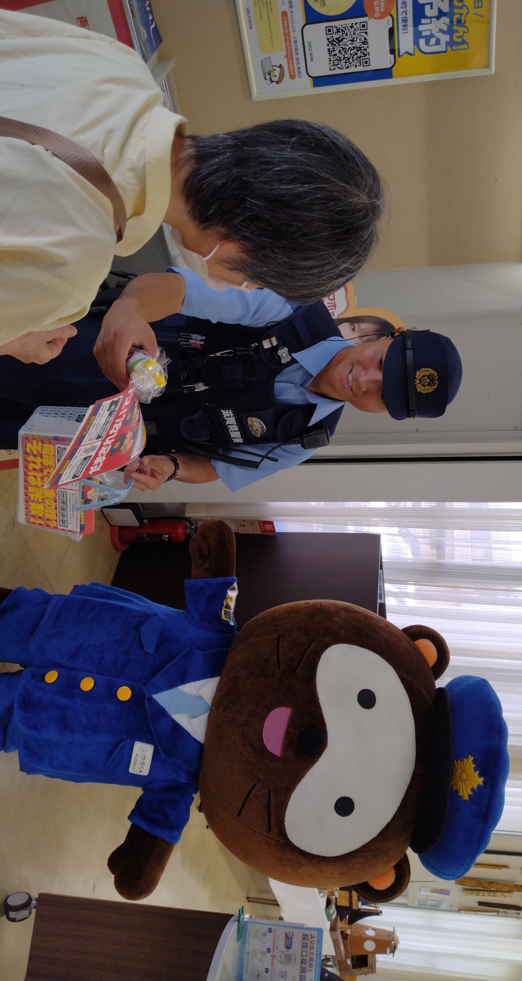 呼びかける警察官とけいたくん