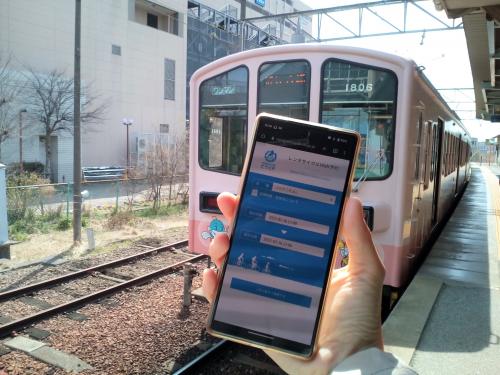 近江鉄道の前でビワイチサイクリングナビアプリを操作する様子