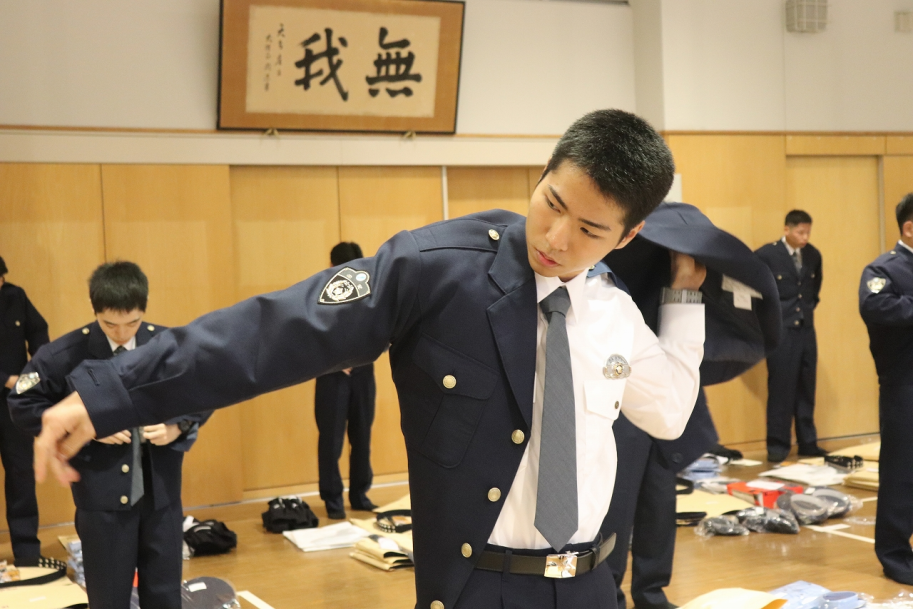 制服の袖に腕を通す学生