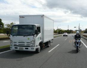 後方の緊急車両と斜め後方の二輪車の写真