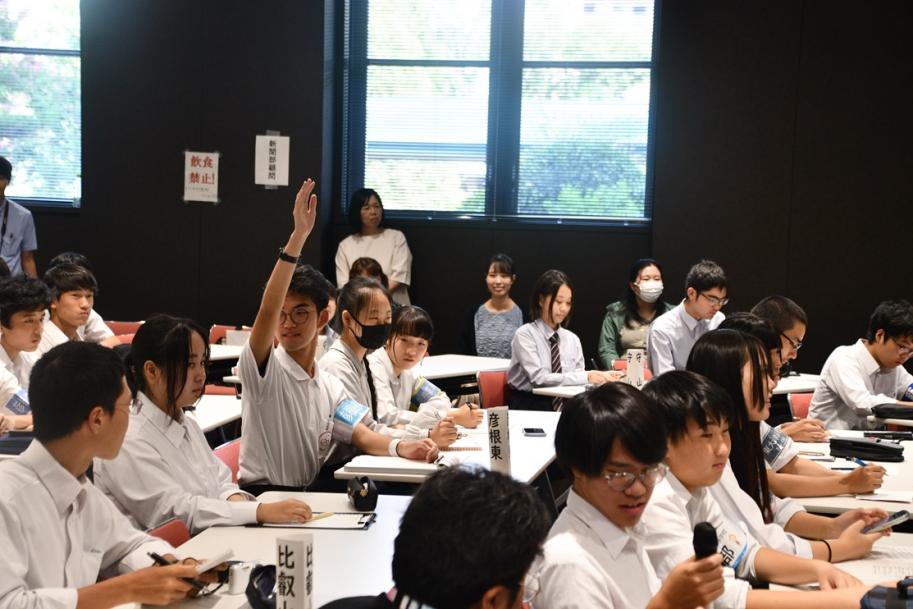 手をあげる高校新聞部員