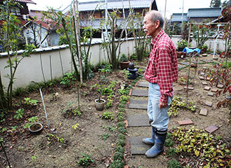 写真:庭に立つ三郎さん