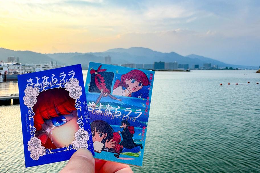 海を背景に撮影された『さよならララ』のカード