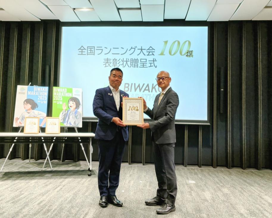 全国ランニング大会100撰の表彰状を持つ三日月大造知事と一般社団法人アールビーズスポーツ財団事務局長の幸村照義氏
