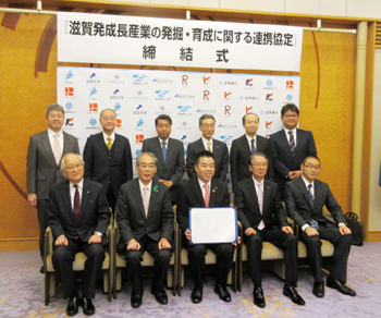 滋賀発成長産業の発掘・育成に関する連携協定の締結式にて6大学、2金融機関ほか関係者と集合写真