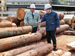木材を指さして話す大津・南部地域木材供給協議会の方々