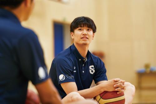森山さんと話す野本さんの写真。手にはバスケットボール。